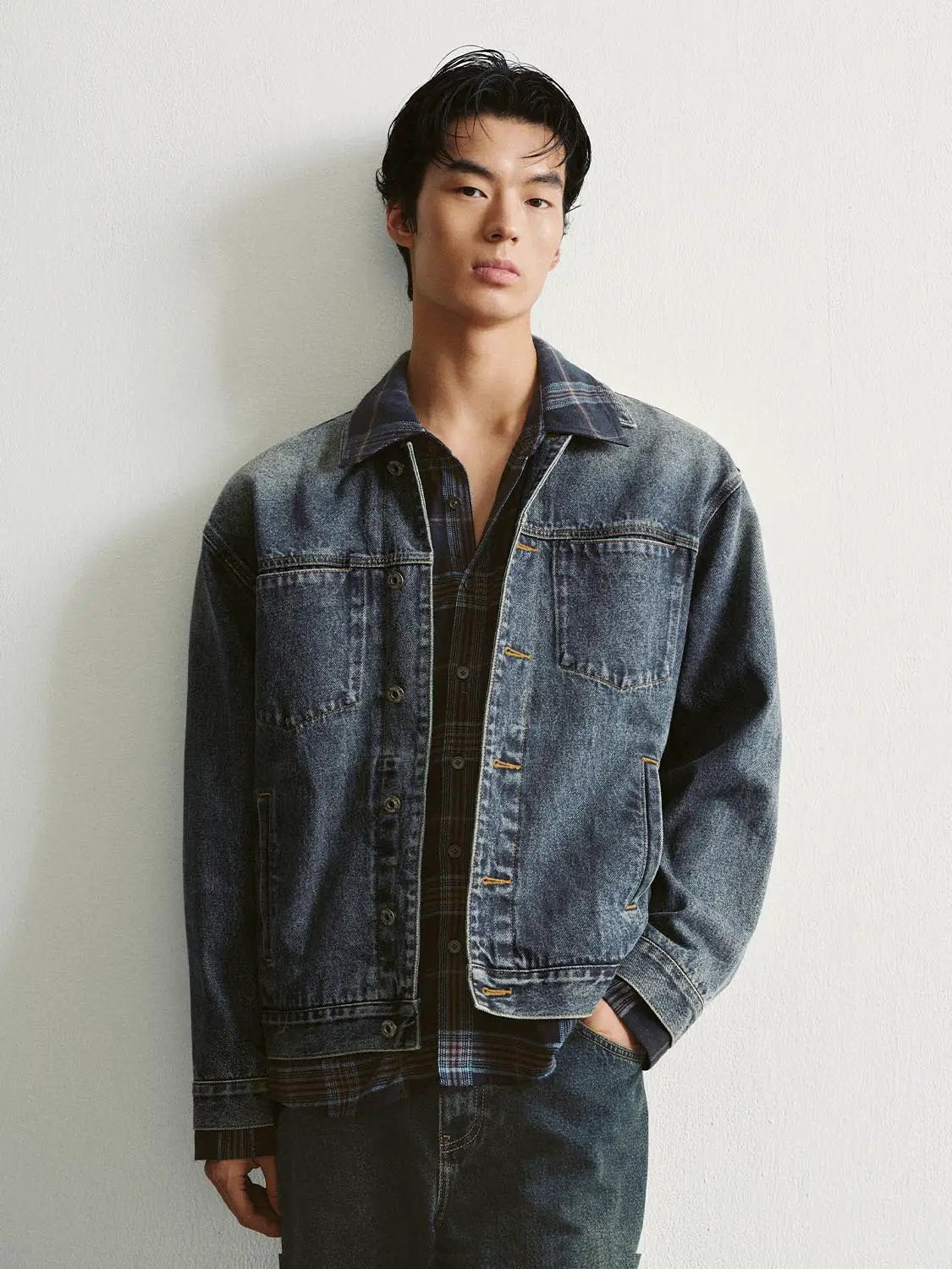 Faded checked-collar cotton long-sleeve denim jacket on a male model, layered over a blue plaid shirt for a rugged look
