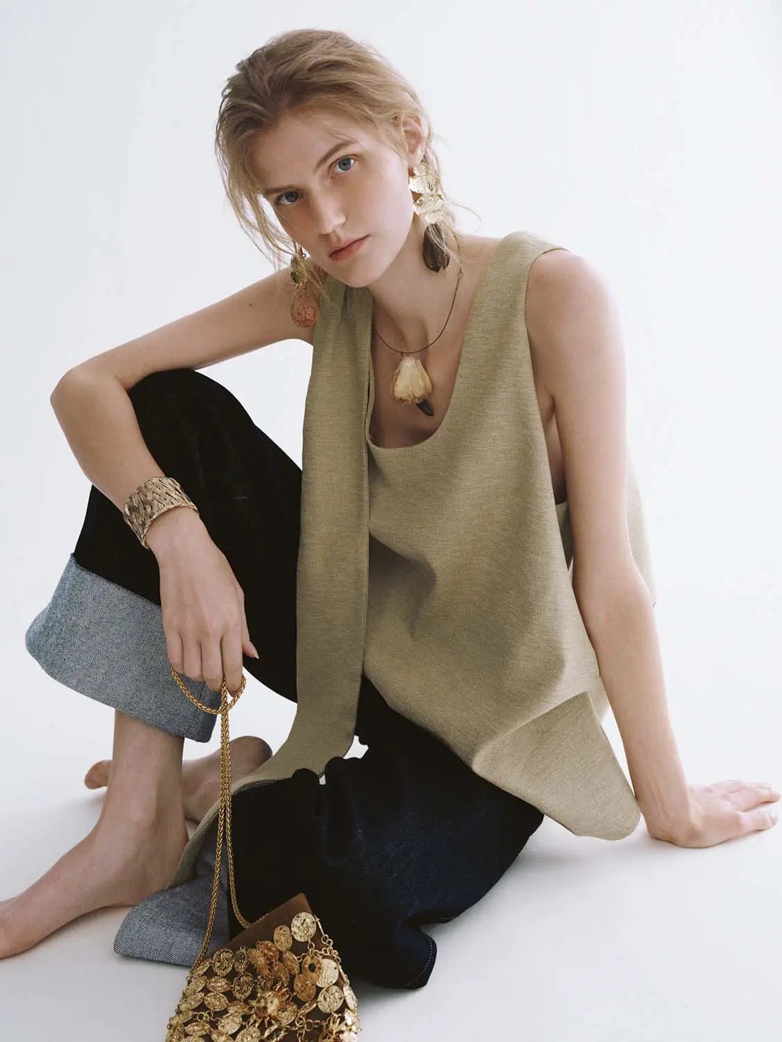 Textured draped overlay beige sleeveless blouse; front drape detail.