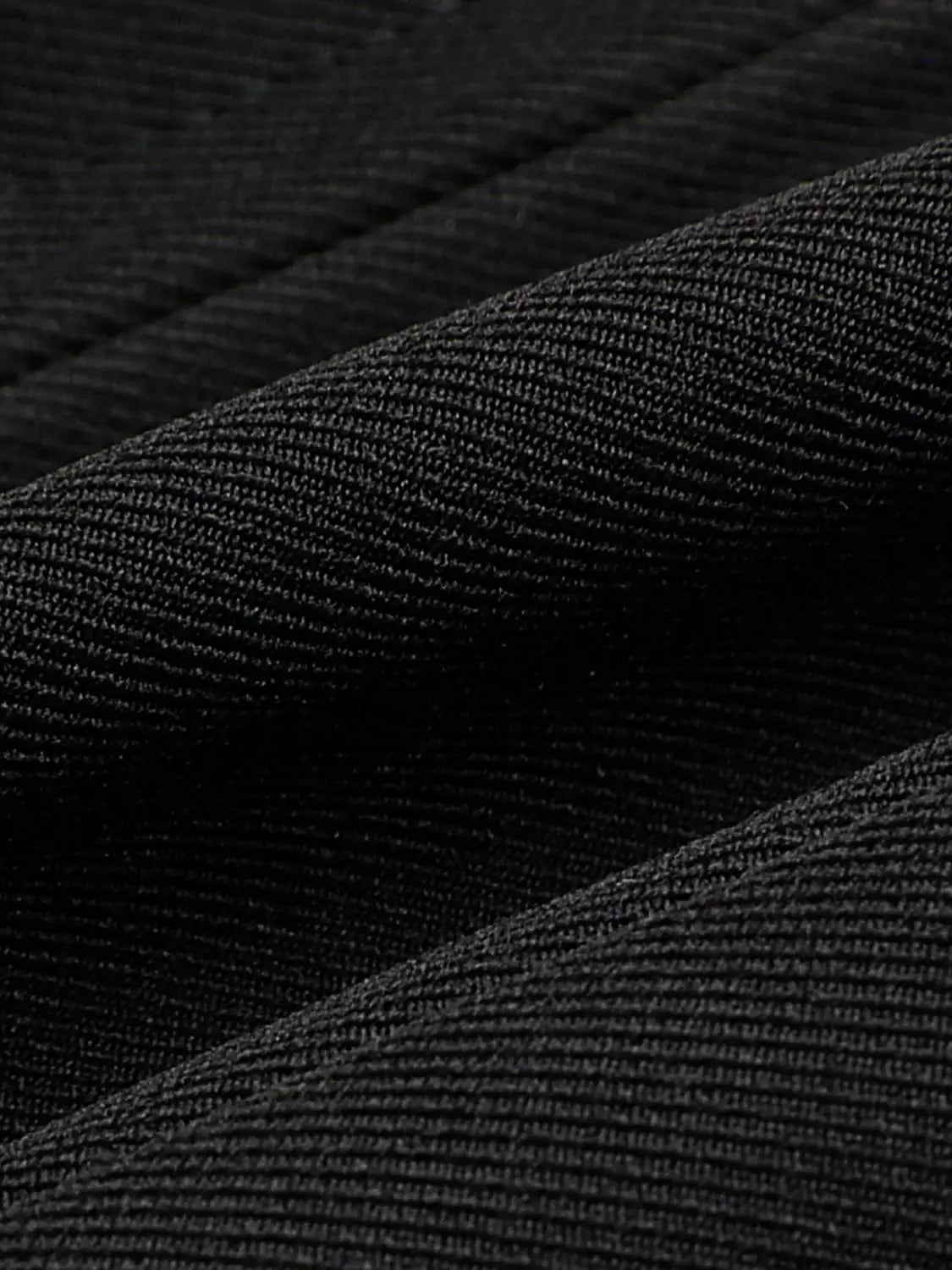 Camisole top fabric close-up in black textured knit