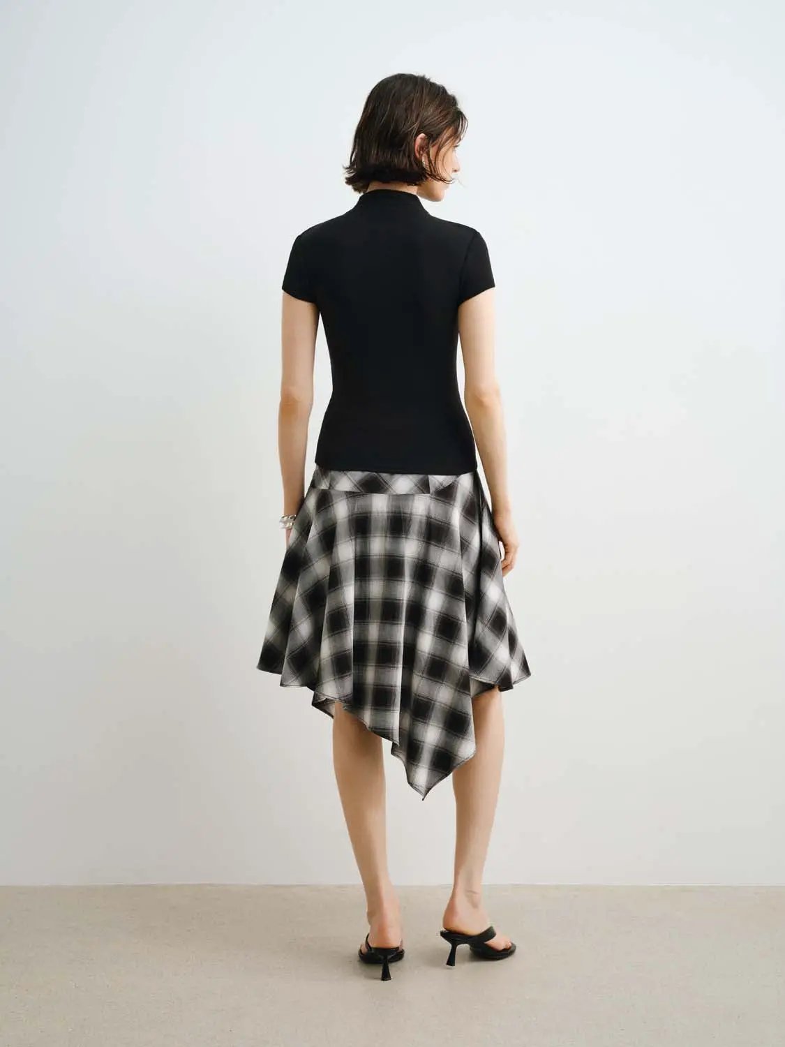 W_T-shirts: black fitted short-sleeve top and black-and-white plaid asymmetrical skirt, two-piece outfit (back view)