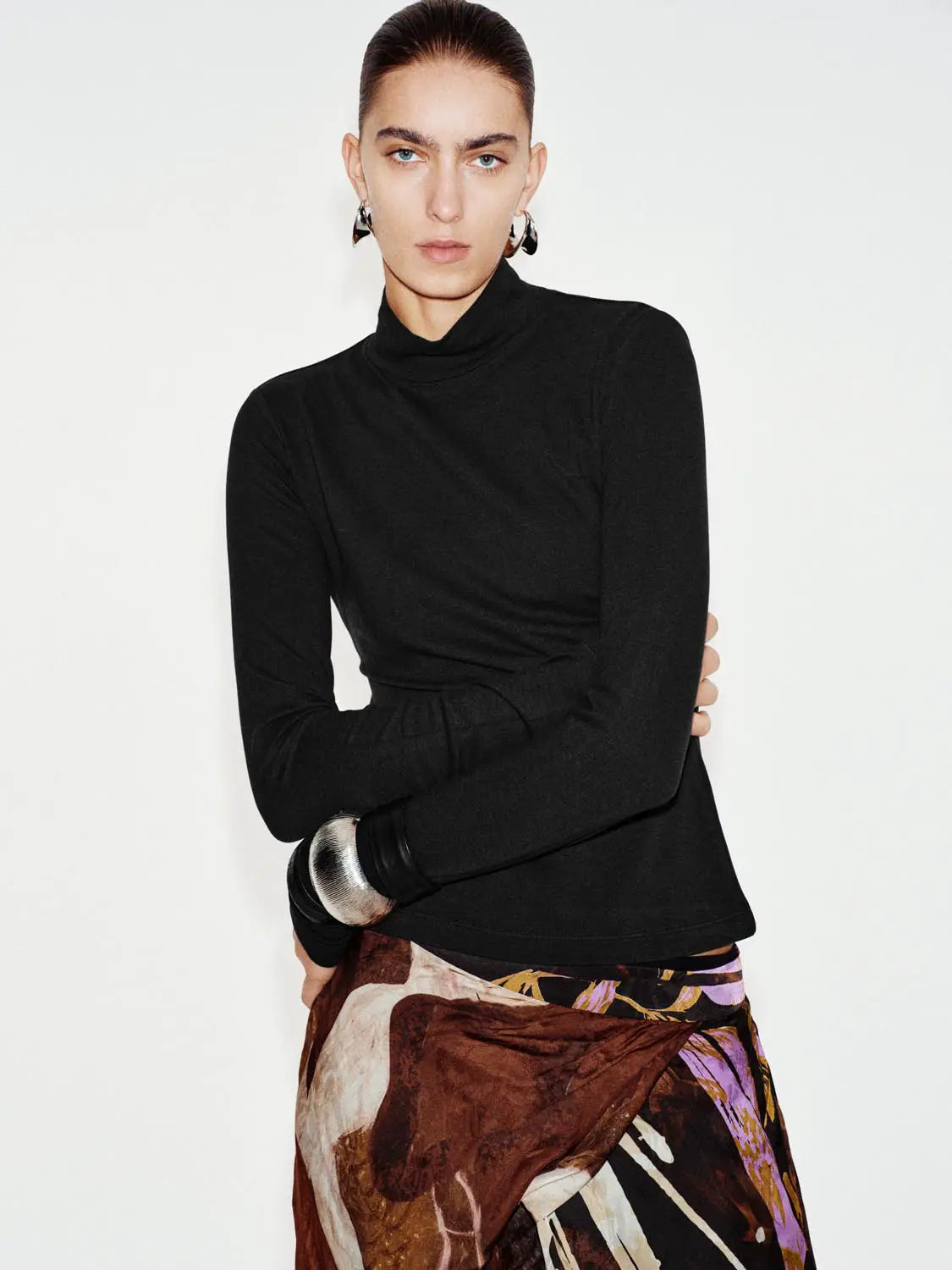 T-Shirt, black long-sleeve turtleneck worn by model against a light background