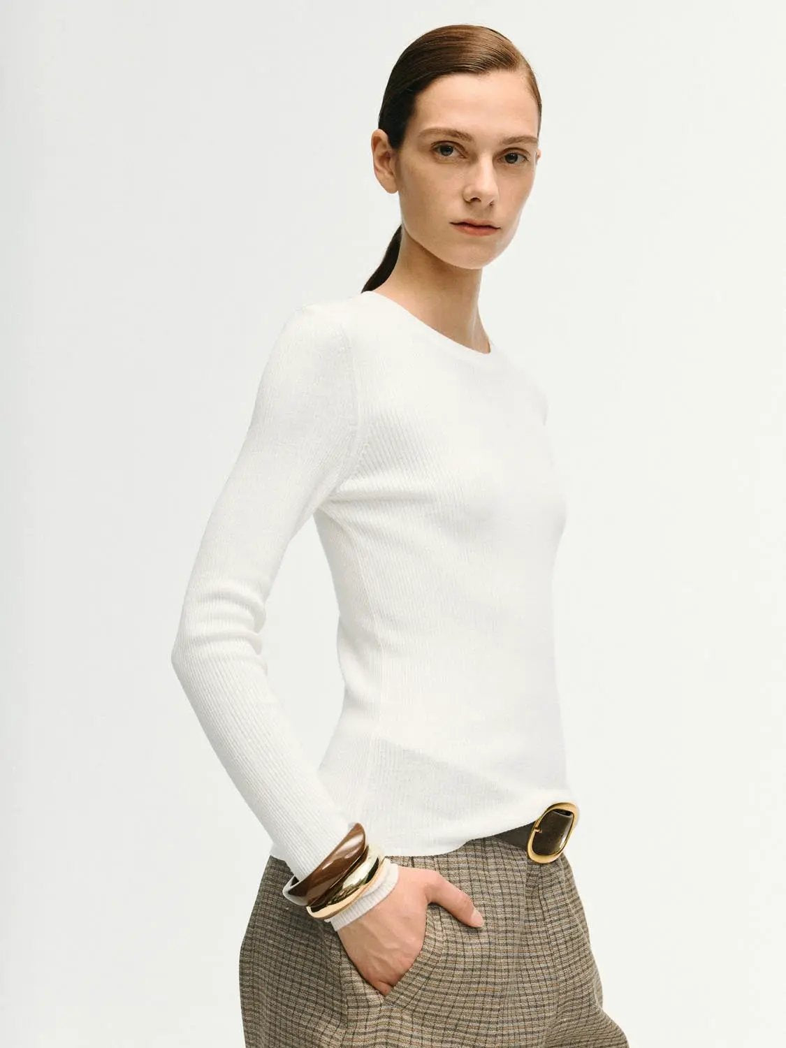 Ribbed fitted white long-sleeve crew-neck T-shirt by Urban Revivo Fashion on model; paired with plaid brown skirt.