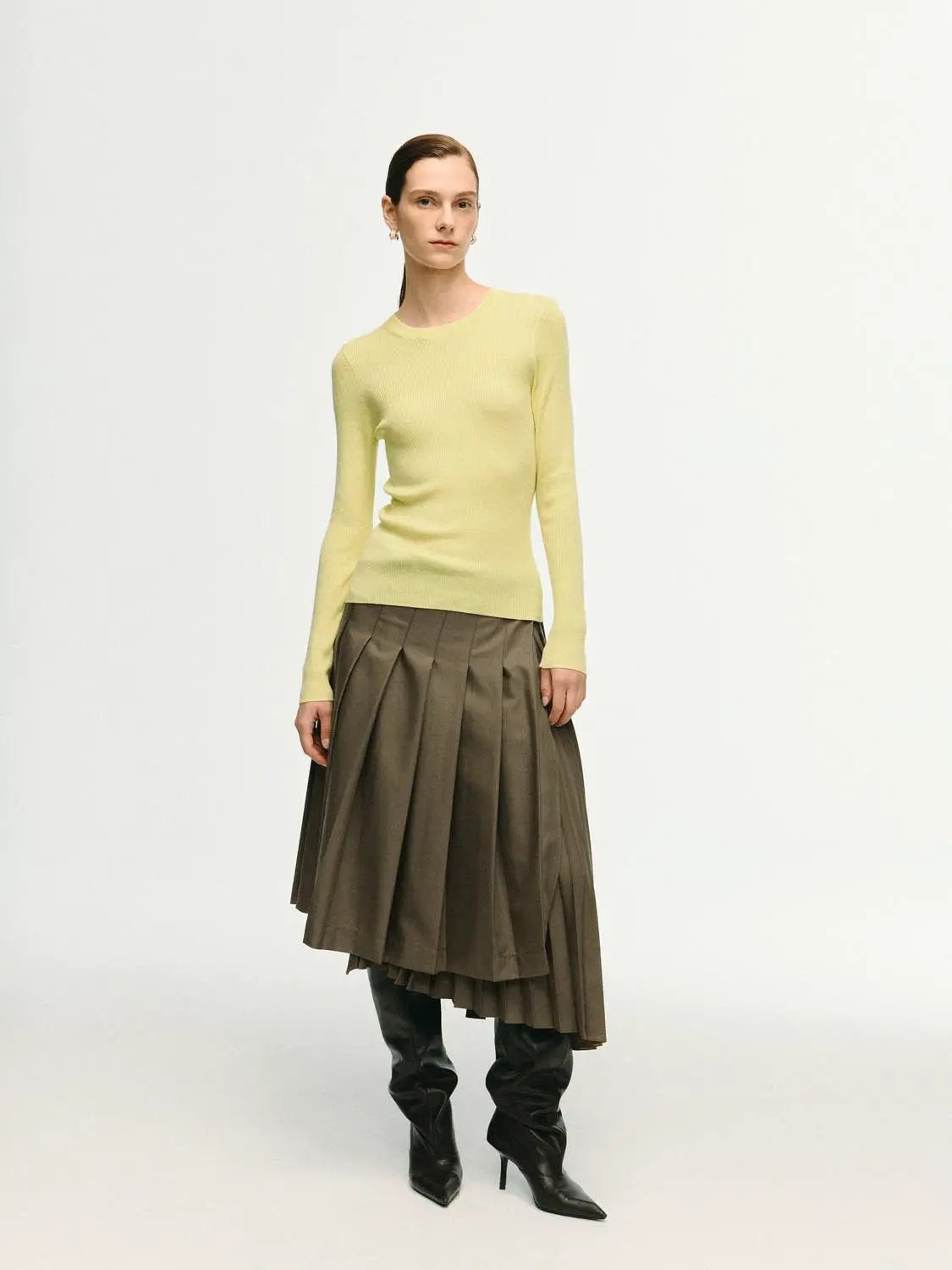 Ribbed fitted long-sleeve crew-neck T-shirt in pale yellow; brown pleated midi skirt and knee-high boots, three-piece.