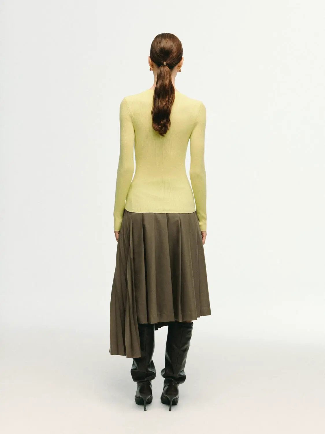 Ribbed fitted long-sleeve crew-neck t-shirt in pale yellow, shown with a brown pleated midi skirt and knee-high boots.
