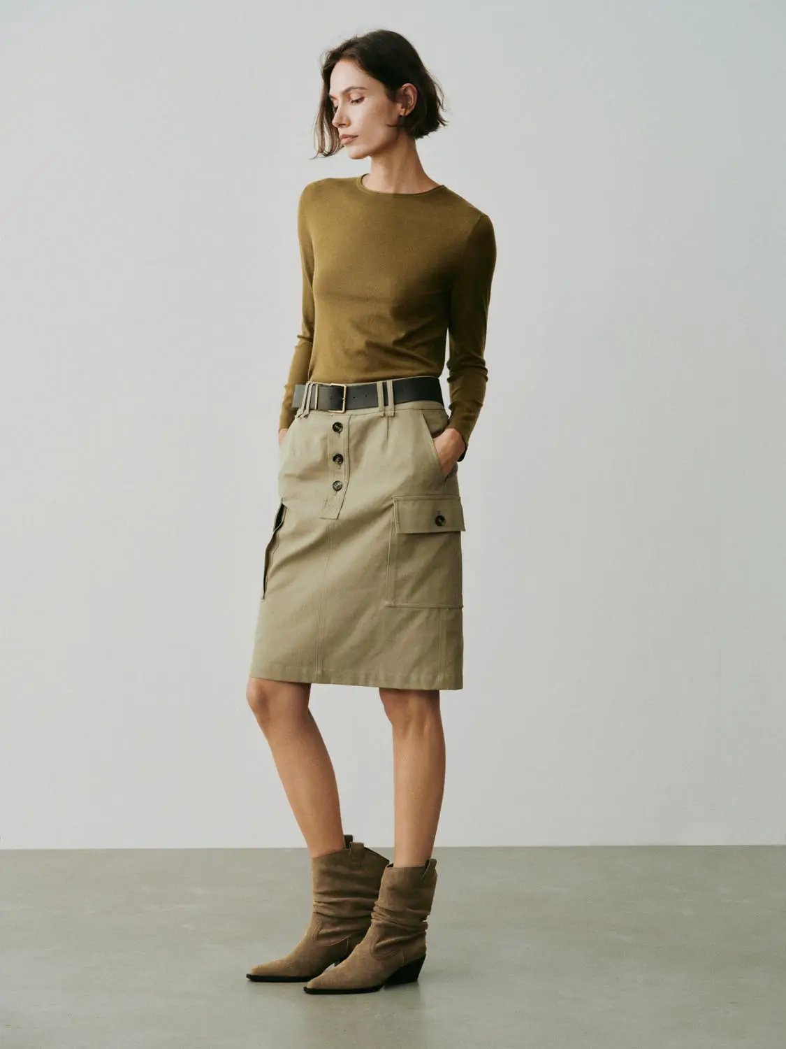 Knit T-Shirt in olive brown on a model with a beige cargo skirt and belt