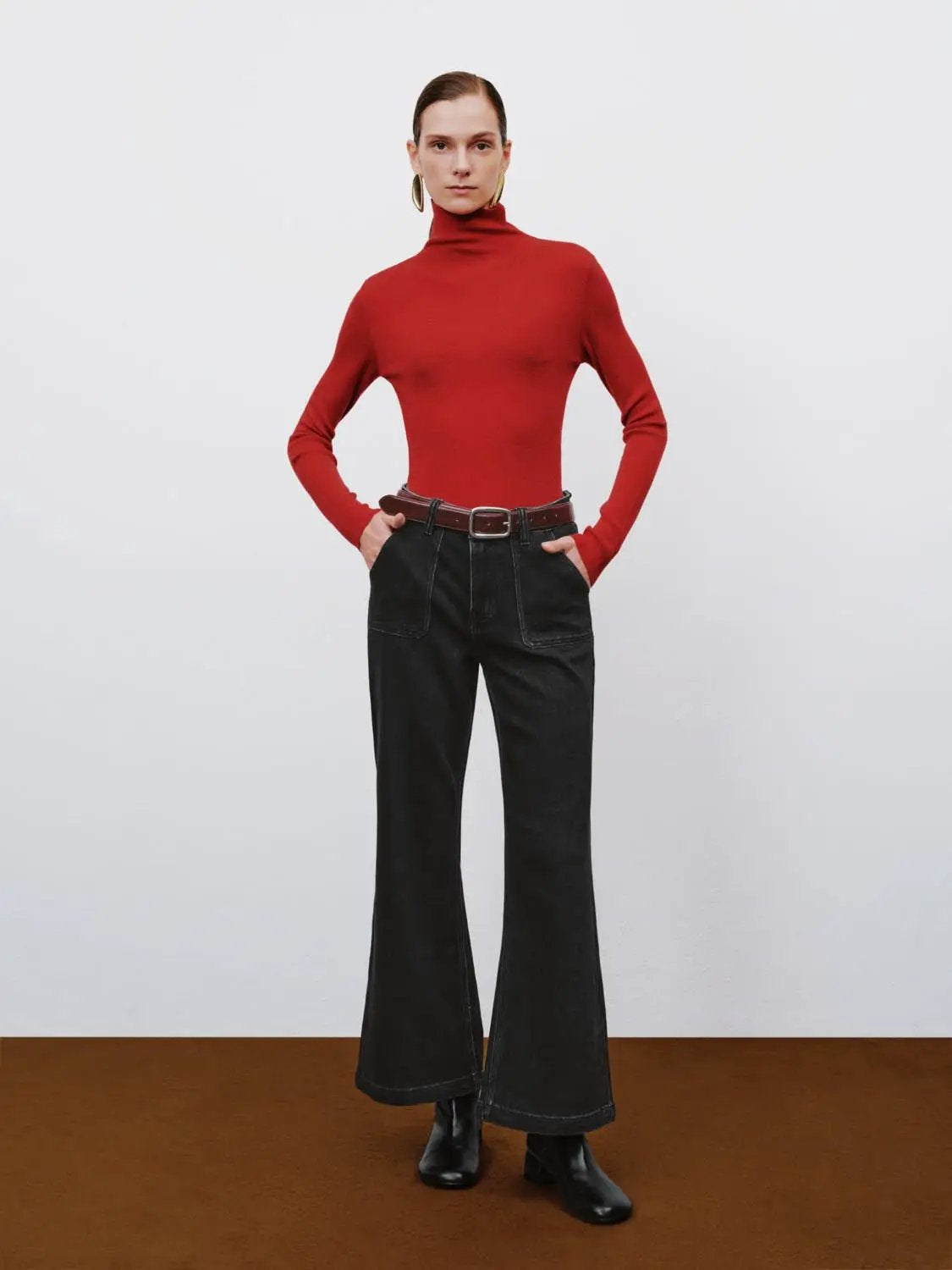 Ribbed fitted mock-neck long-sleeve sweater in red, paired with black wide-leg denim pants and a brown belt