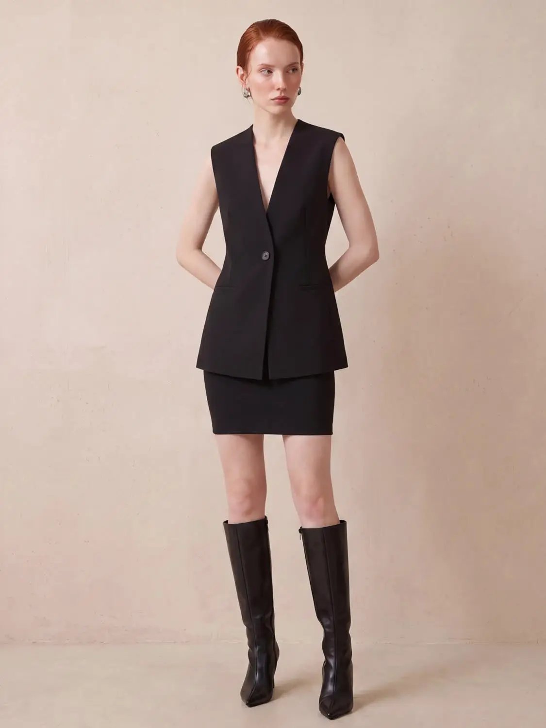 Sleeveless Single Button Vest in black worn with a matching black pencil skirt.