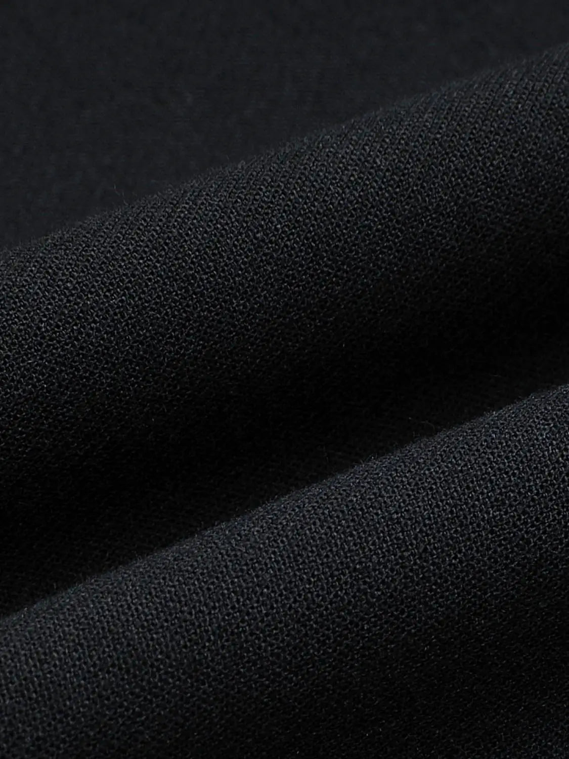Jacket fabric close-up in black knit texture for a sleek versatile look
