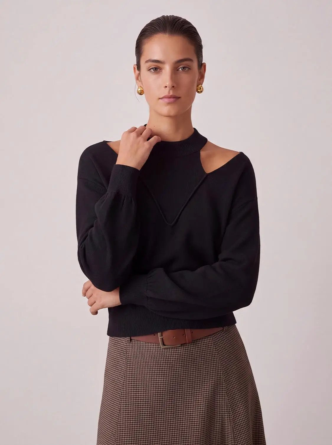 Cut-Out long-sleeve knitted T-shirt in black with shoulder cutouts, worn by model.