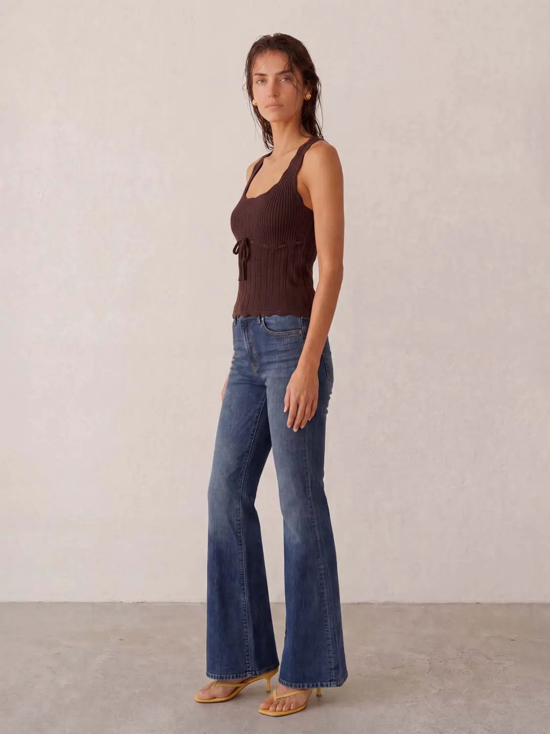 Knit tank top in brown with waist tie by Urban Revivo Fashion, paired with blue jeans.