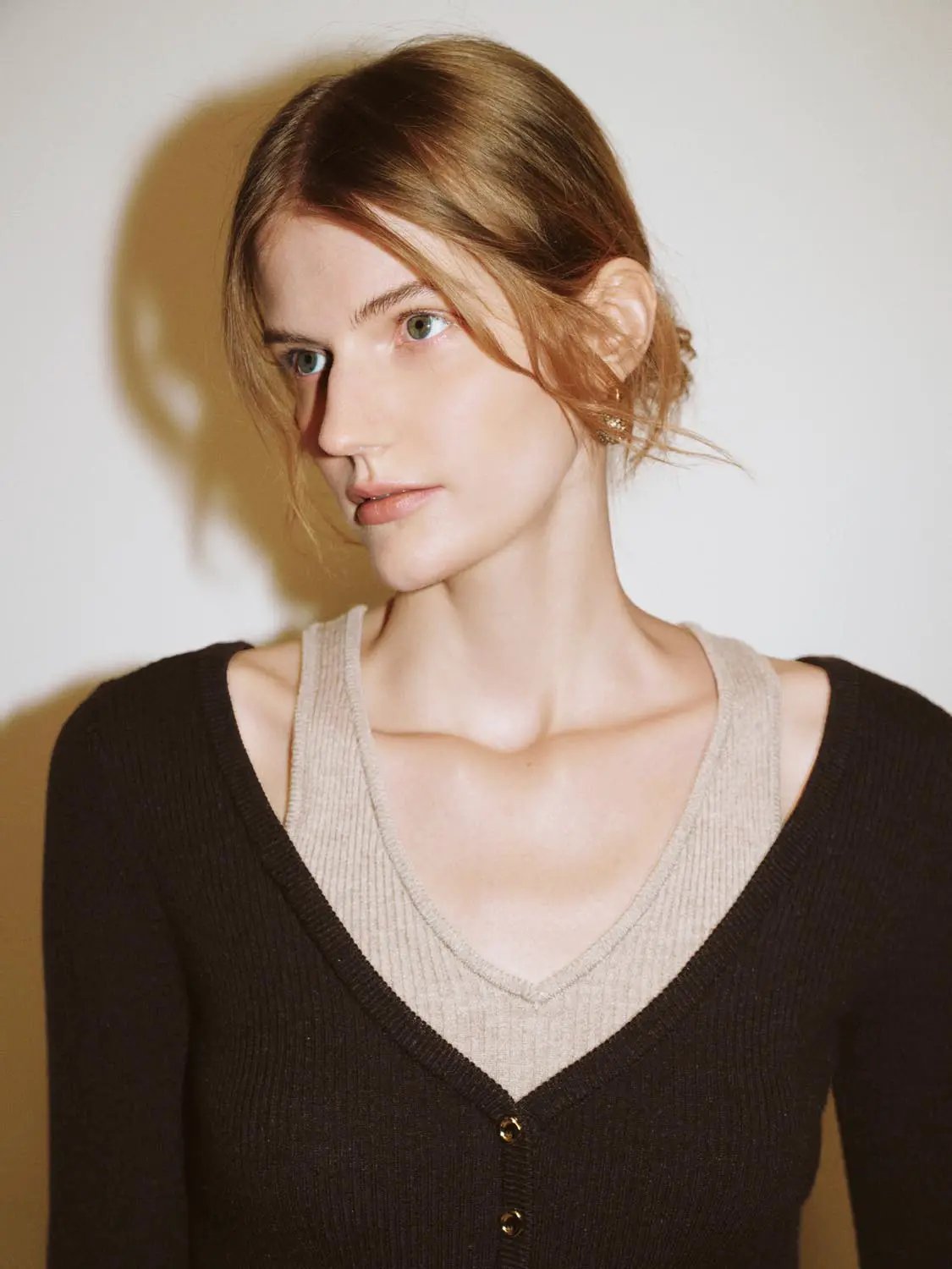 Knit T-shirt in beige knit fabric worn by a model with a black cardigan.