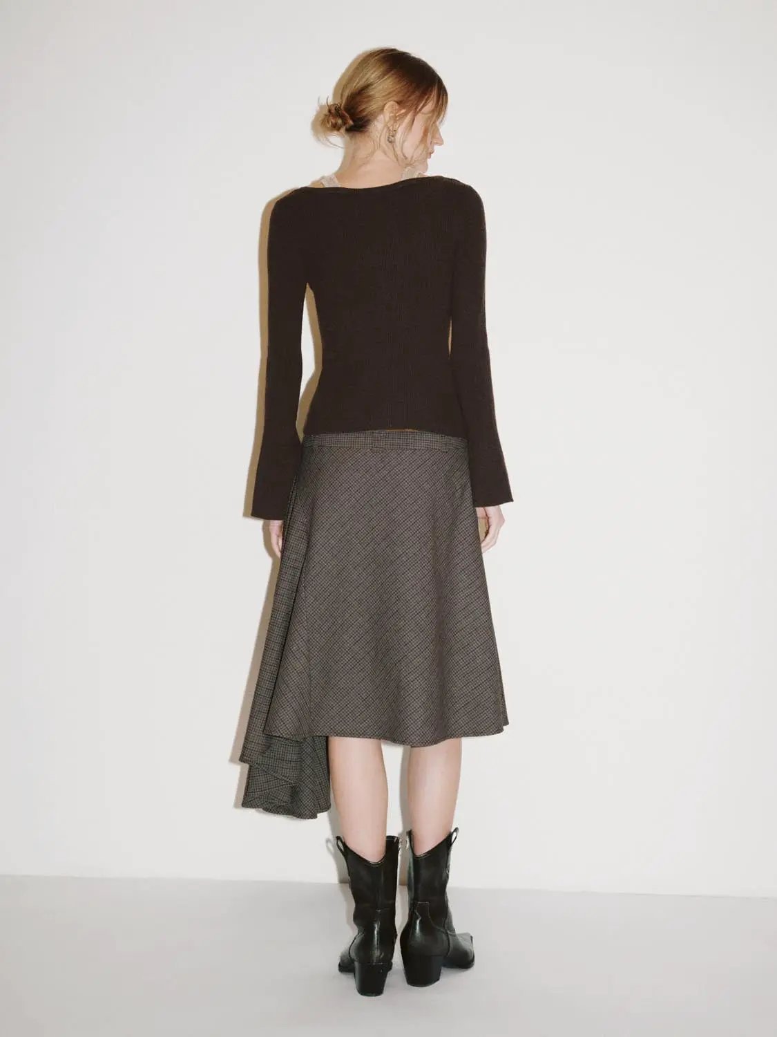 Knit T-Shirt dark brown knitted long-sleeve top, back view, paired with a grey-check midi skirt and black boots