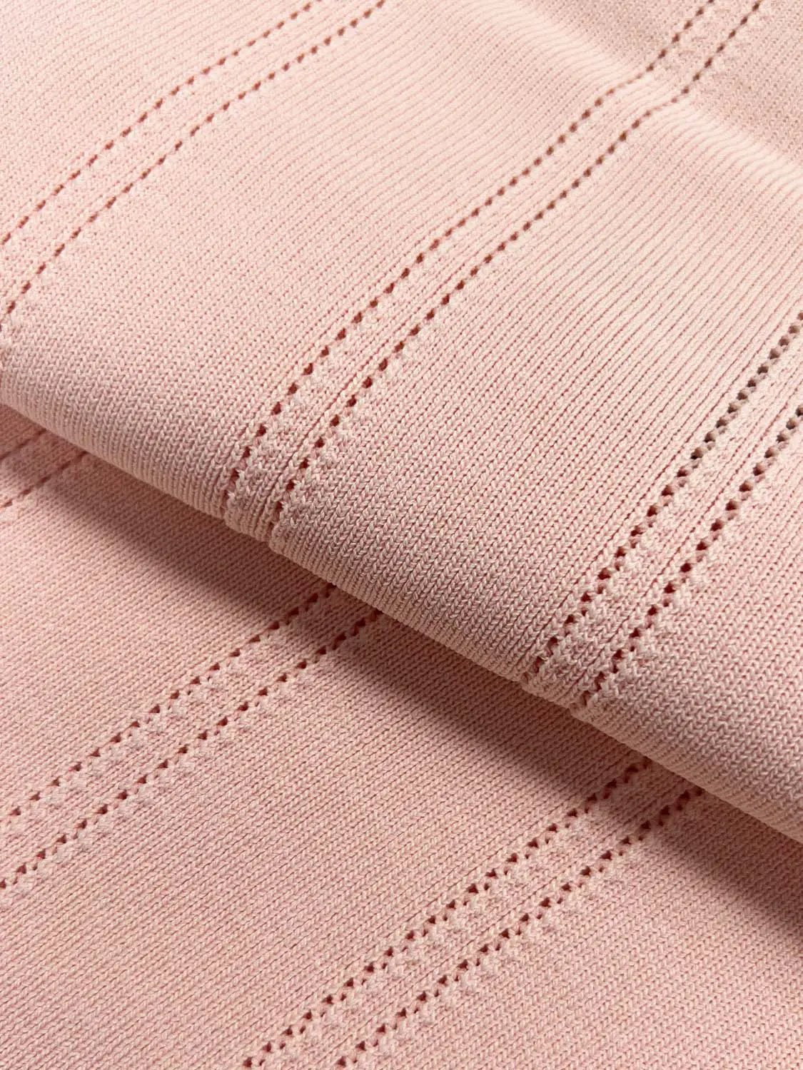 Knitted T-Shirts pink fabric close-up with ribbed knit stitches and seams