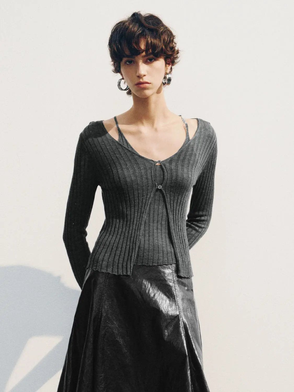 Fitted ribbed V-neck cardigan with button front in charcoal gray; worn with a black skirt by Urban Revivo Fashion.