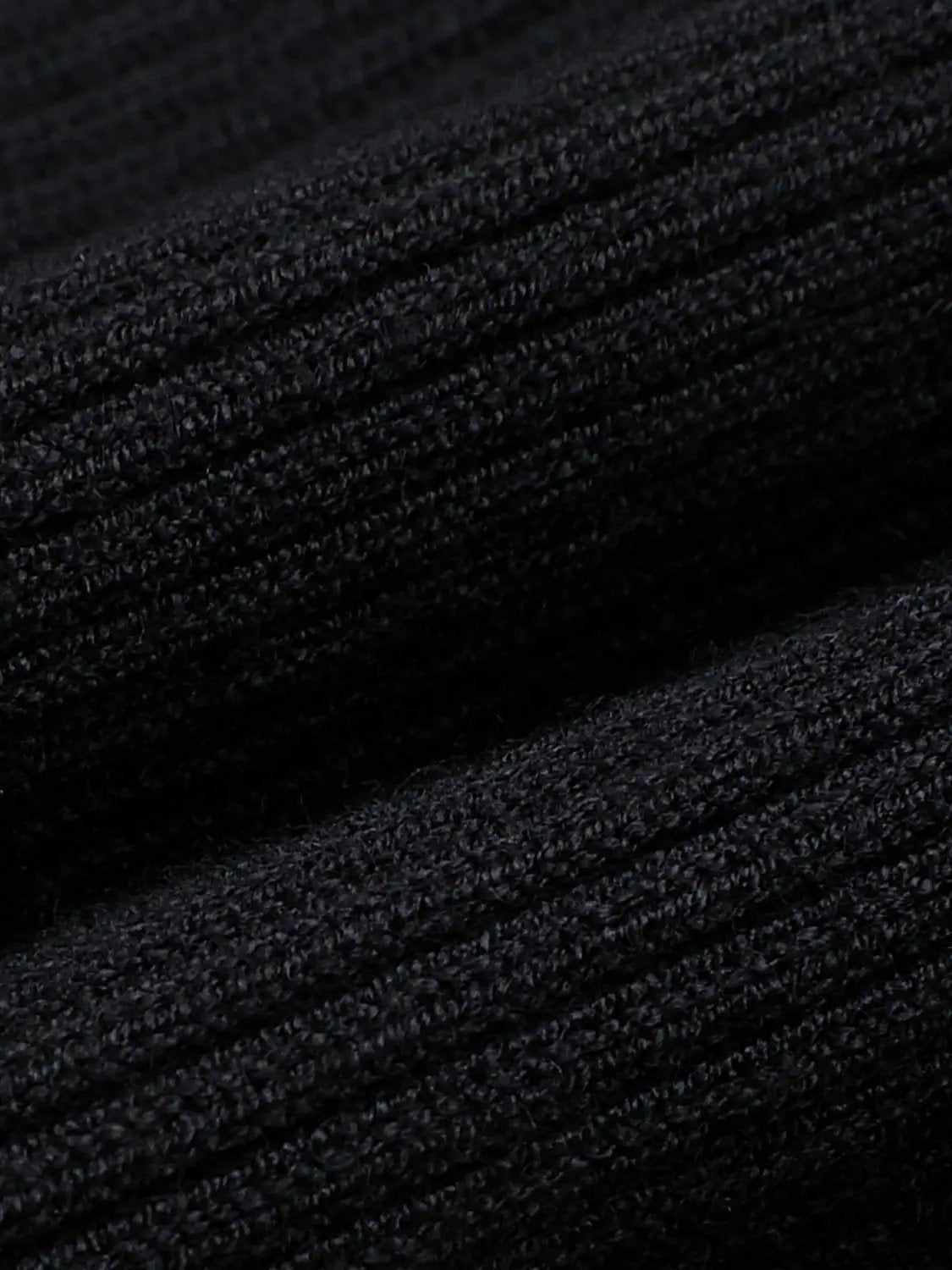 Knit dress fabric close-up in black with textured rib knit
