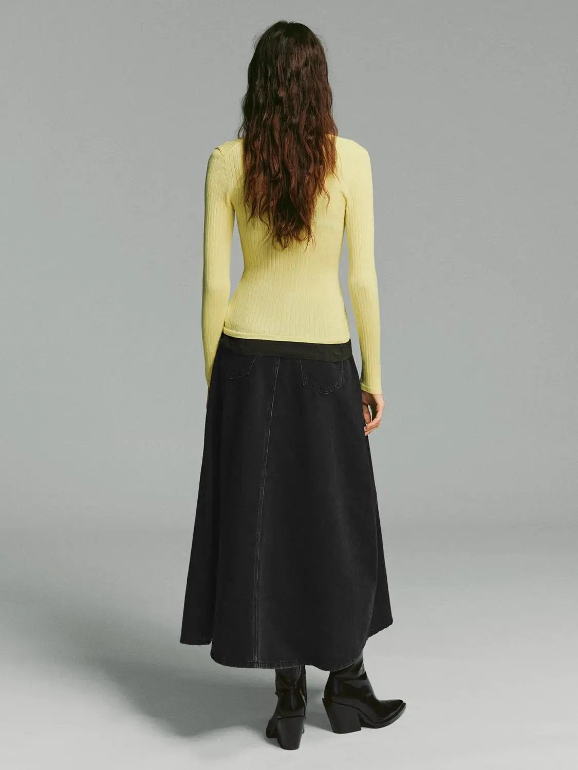 Ribbed button-front V-neck long-sleeve cardigan in pale yellow worn with a black skirt