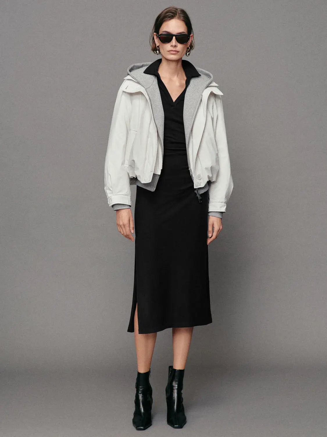 Down jacket white, oversized; worn over a black midi dress