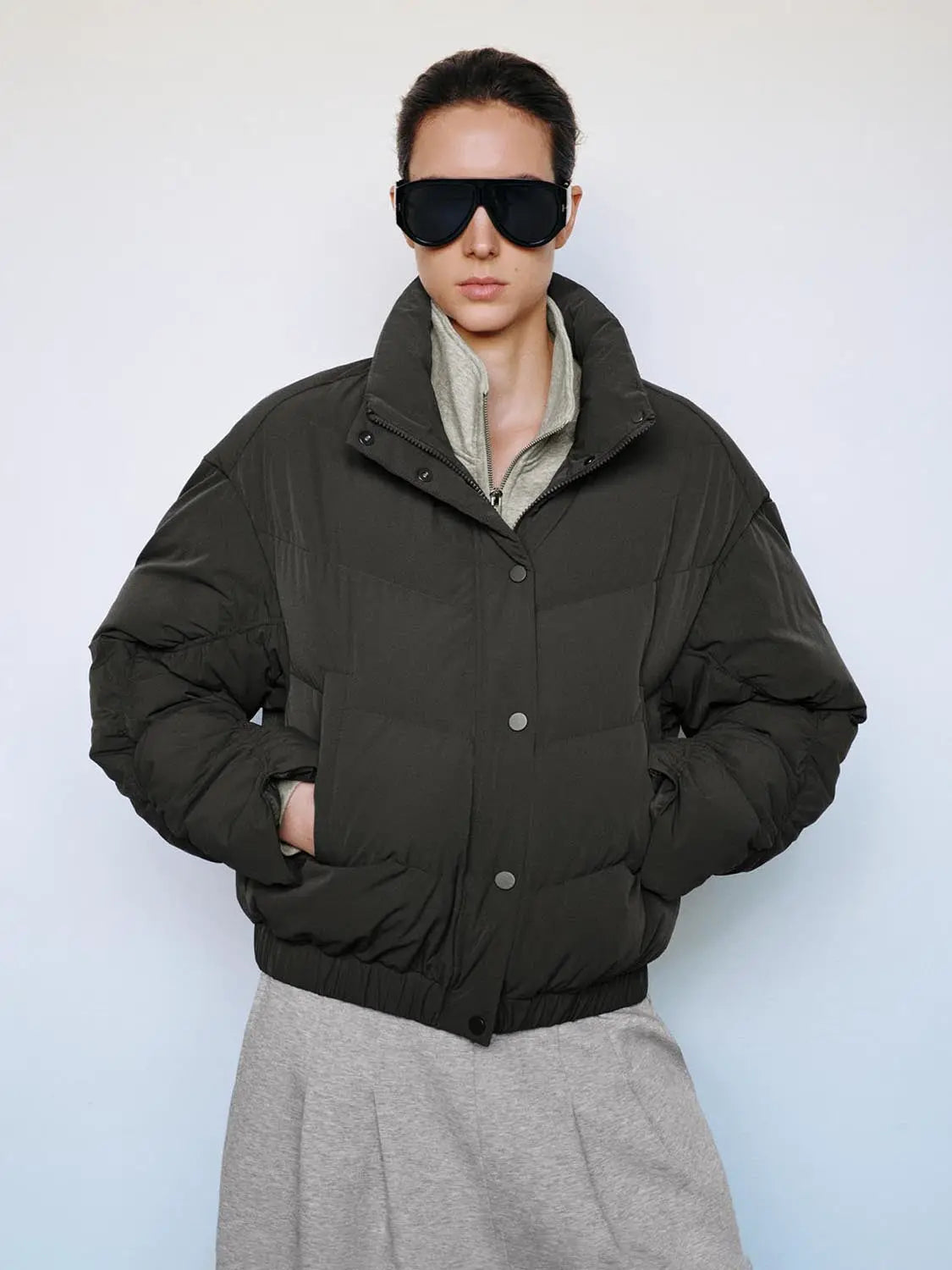 Down jacket oversized puffer in dark olive with a high collar.