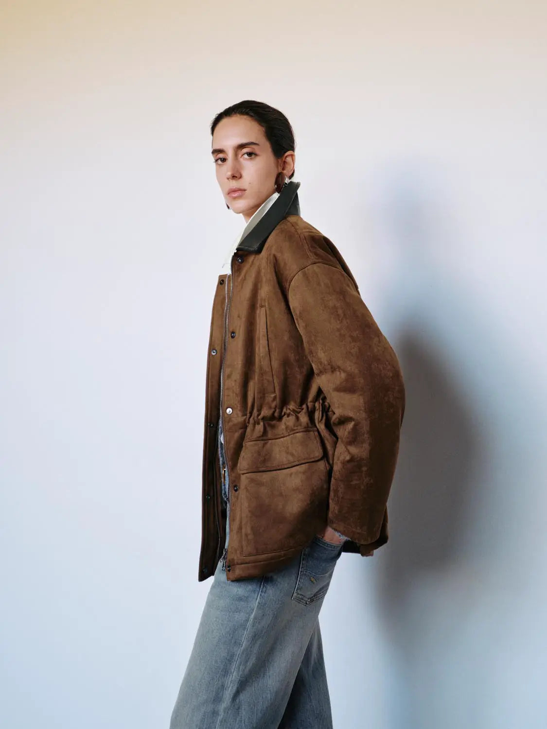 Padded jacket brown suede with dark green collar; front zip and snap buttons, shown on a model.
