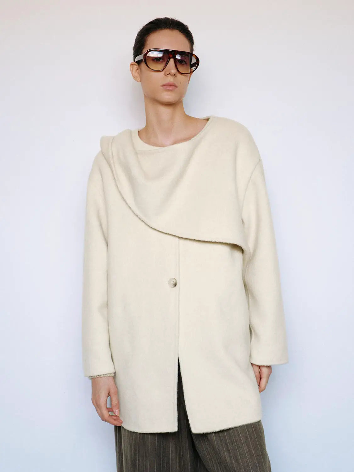 Coat in cream with draped wrap collar, long sleeves and single front button