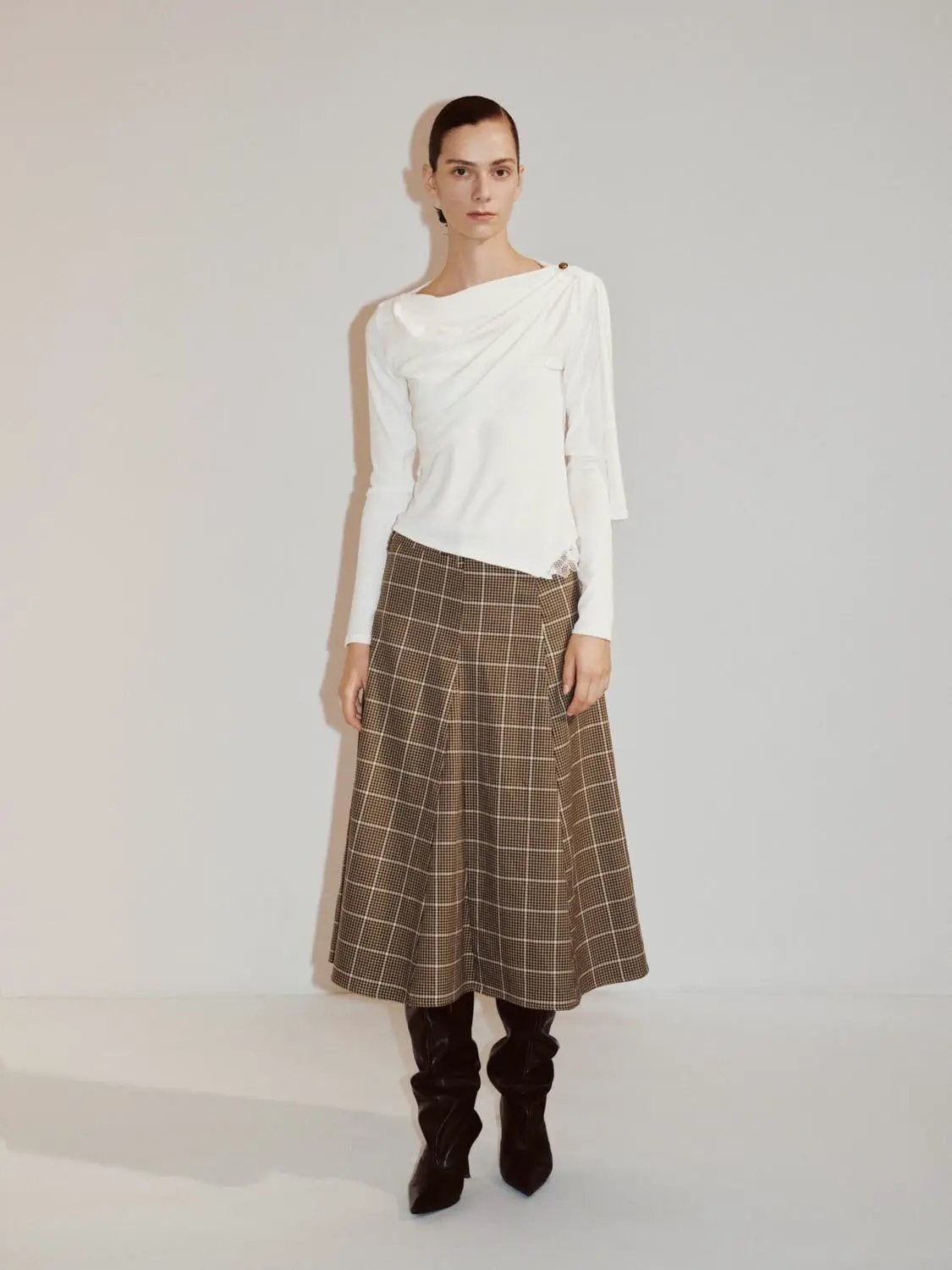 Draped One-Shoulder Long Sleeve Blouse in white, two-piece outfit with brown plaid midi skirt and black knee-high boots.