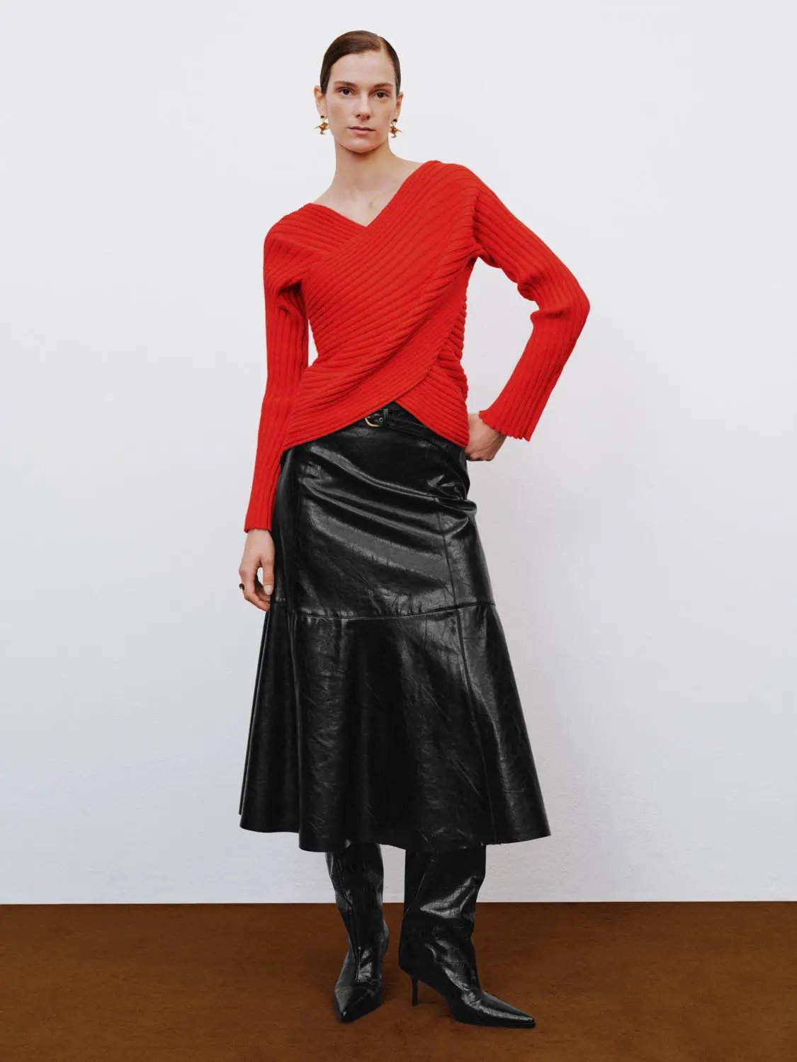 A-Line skirt in black faux leather; midi length with visible seam panels.