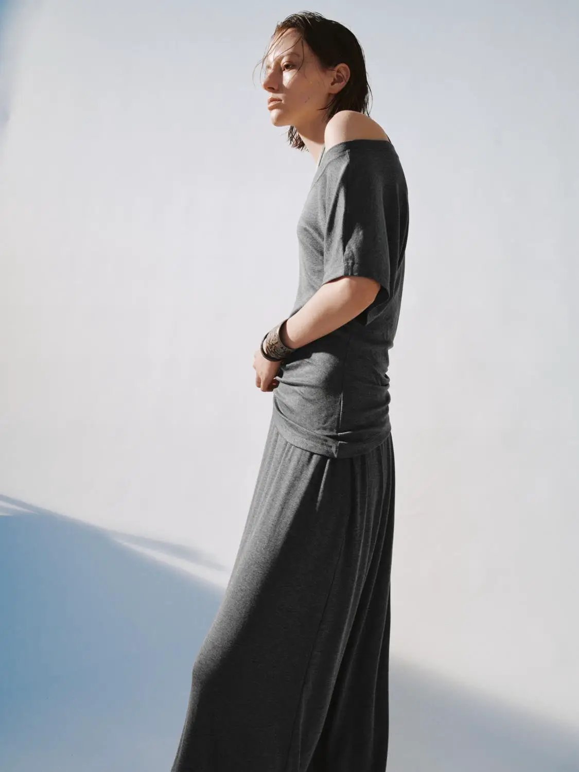 Boat neck off-shoulder draped gray straight midi dress worn by a model