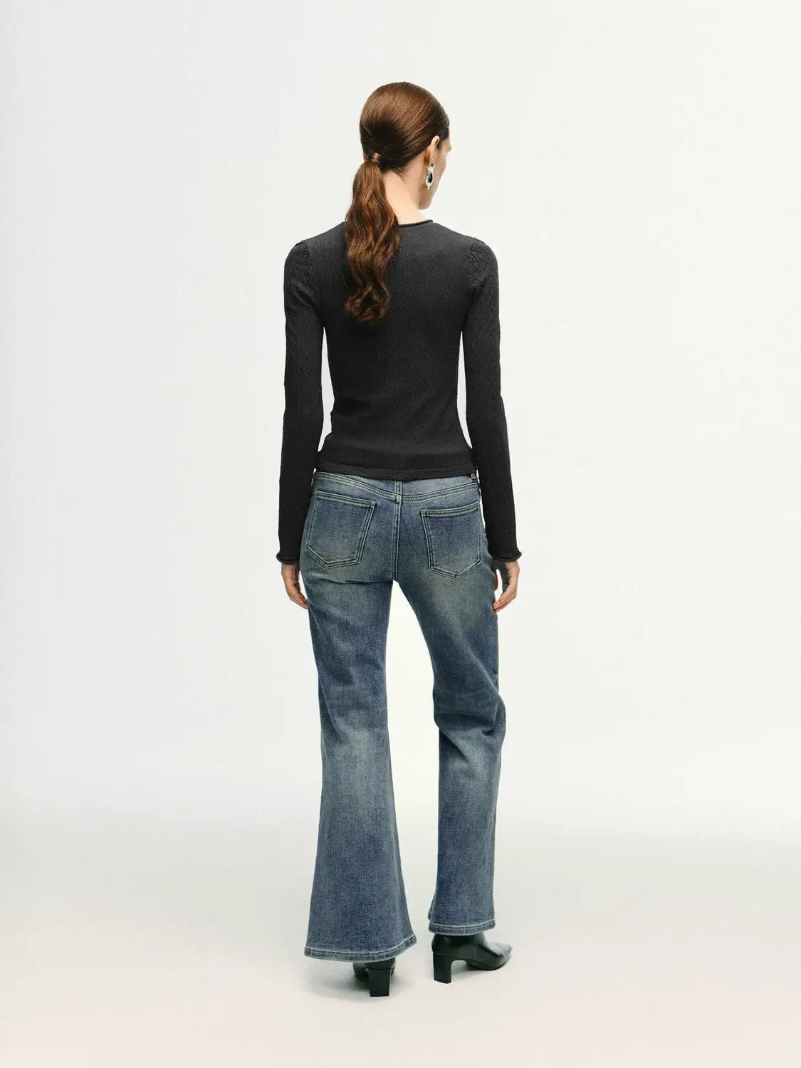 High-waisted stretch cotton blend flare jeans; back view on model in blue denim