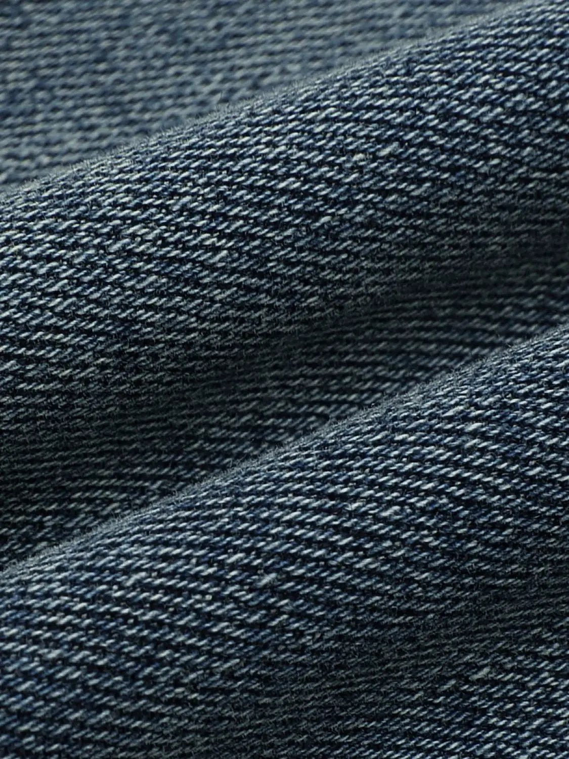 High-waisted stretch cotton-blend flare jeans fabric close-up in blue denim