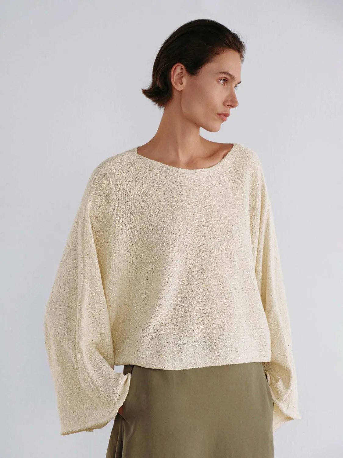 Oversized cropped textured boat-neck knit sweater in cream with drop-shoulder sleeves.