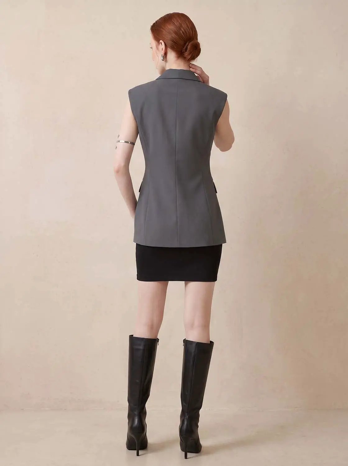 Sleeveless grey lapel-collar vest, back view with structured seams.