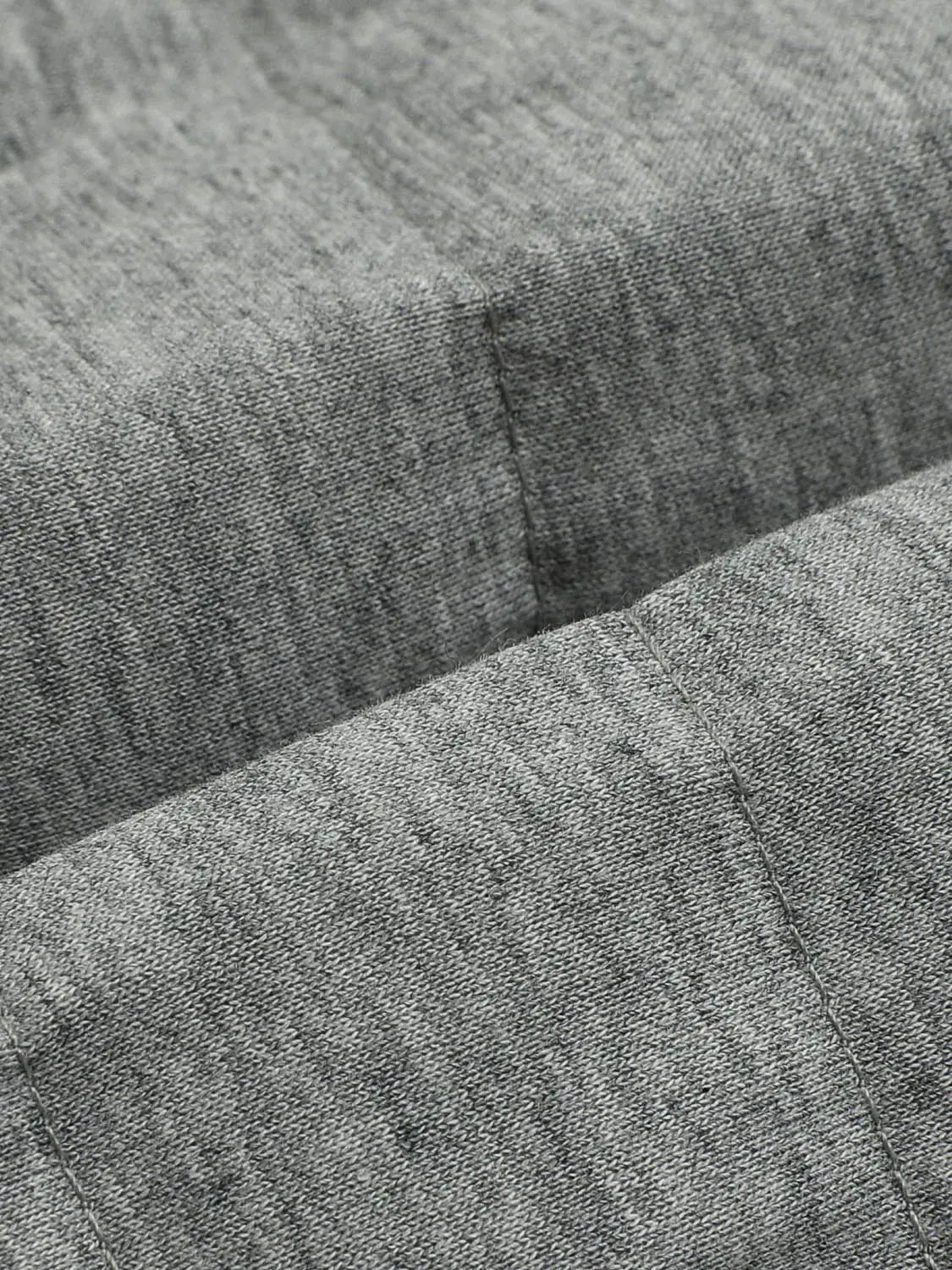 Down Jacket close-up in grey heathered fabric with visible stitching detail.