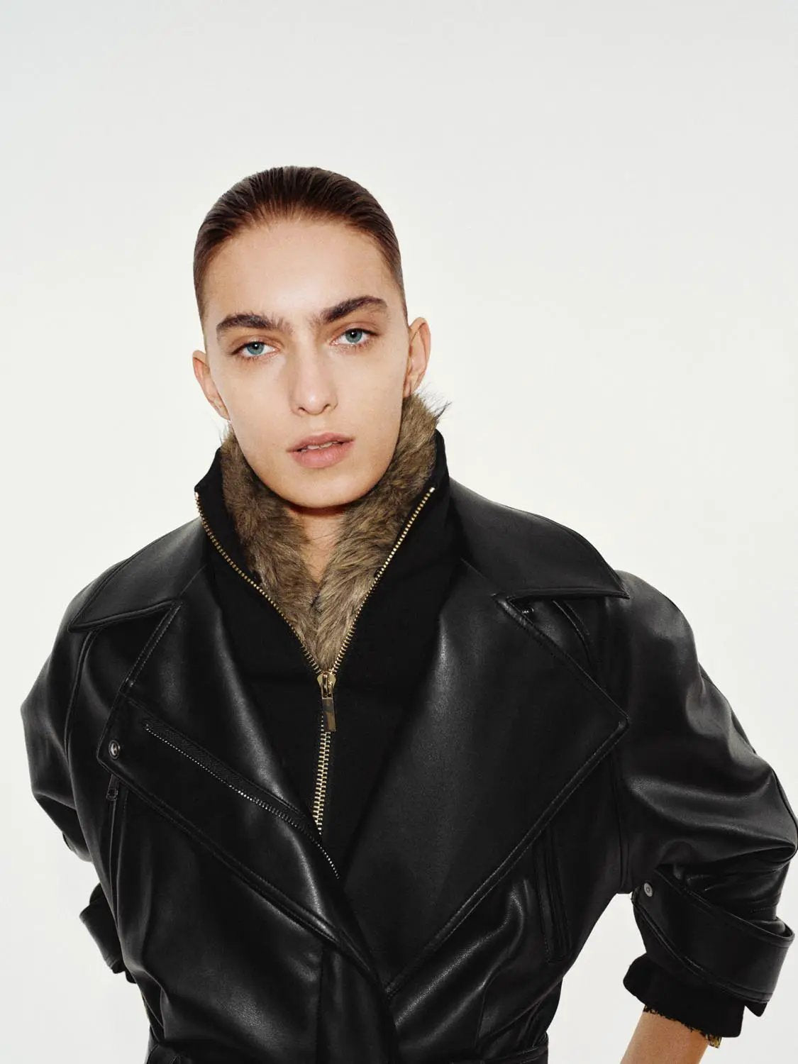 Jacket, black leather with fur-lined collar, gold front zipper and zip pockets.