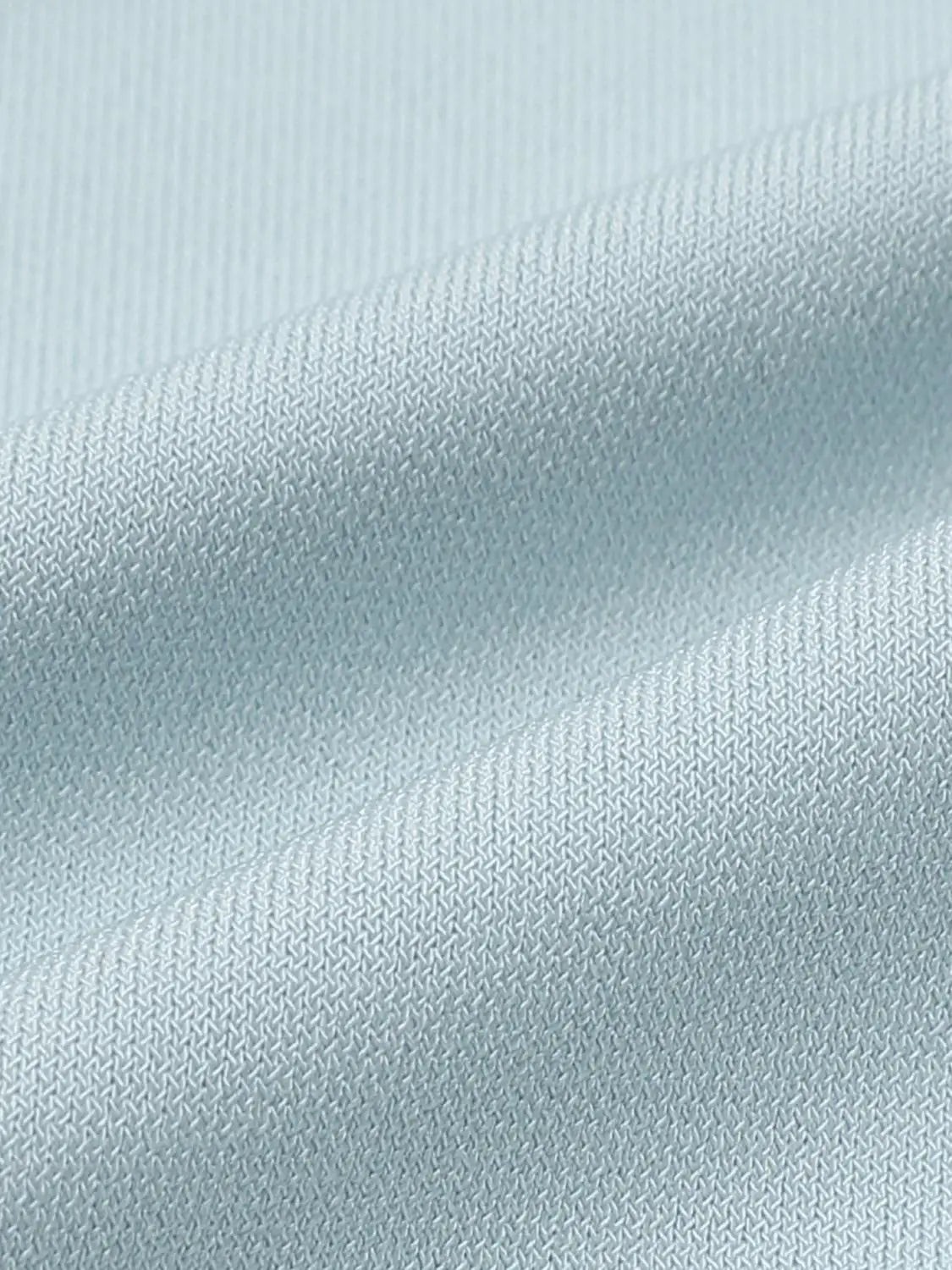 T-shirt fabric close-up in light blue with fine knit texture.