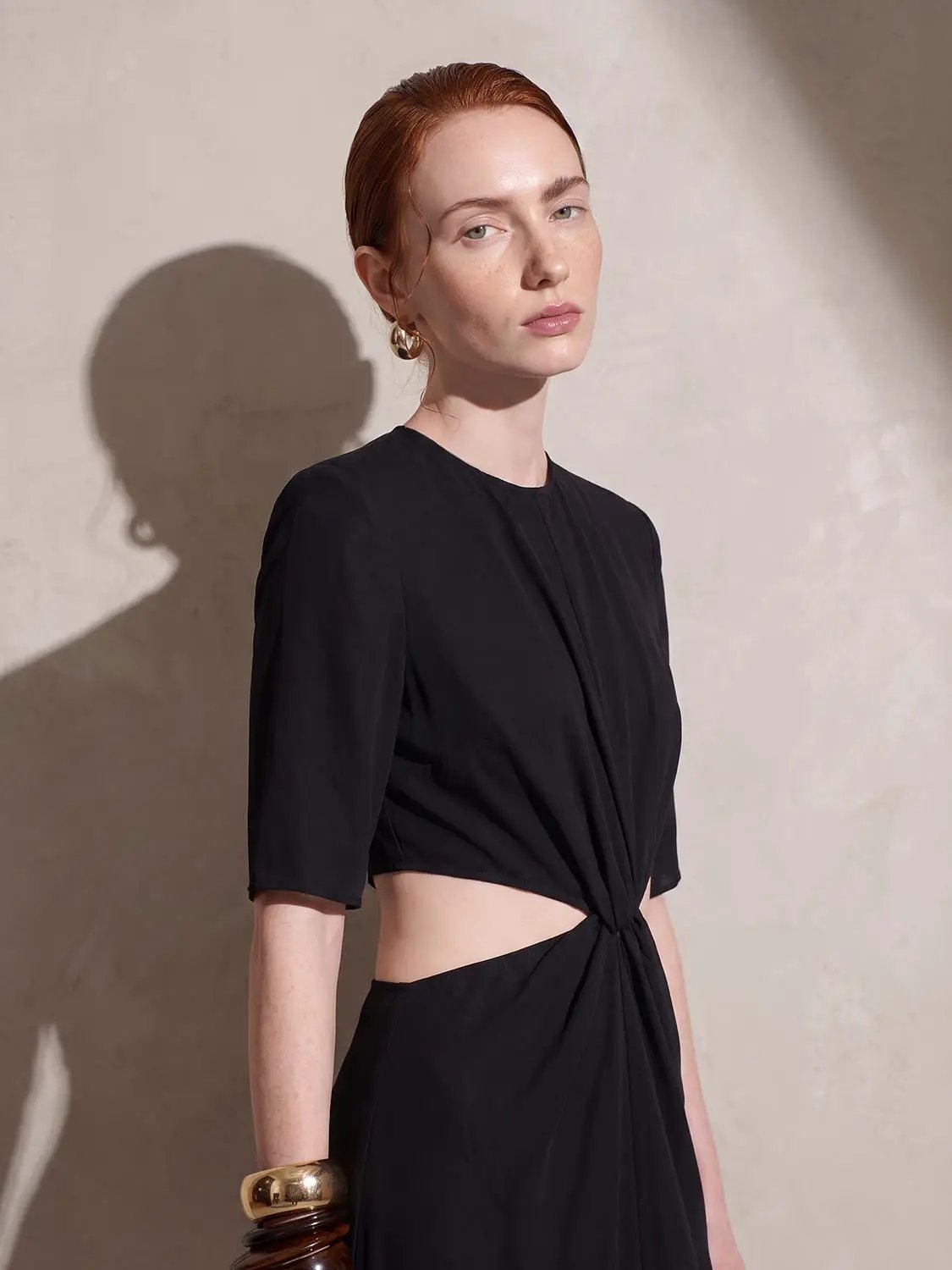Round Neck Padded Shoulder Cutout Knotted Waist Midi Dress by Urban Revivo in black worn by model
