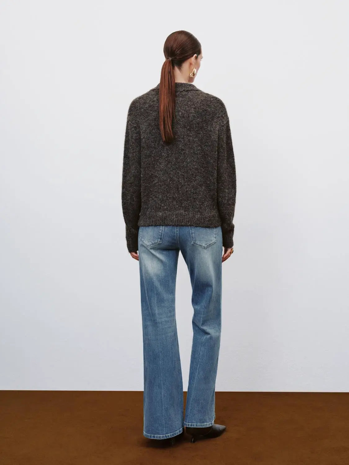 Jeans blue denim wide-leg back view of model wearing a dark knit sweater