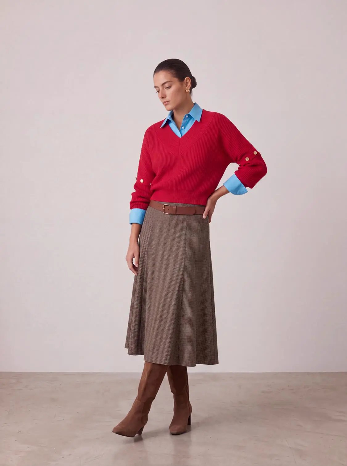 V-Neck Long Sleeve Knitted T-Shirt in red, layered over a blue shirt with brown belt and check midi skirt.