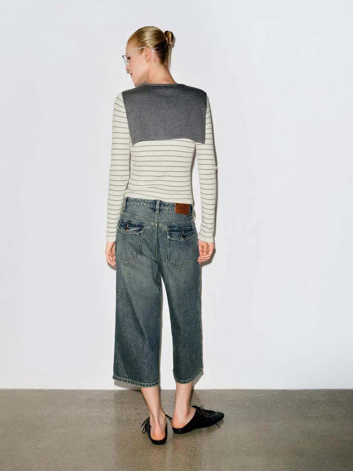 Striped white-and-black fitted V-neck knit T-shirt with gray shawl back panel; long sleeves.