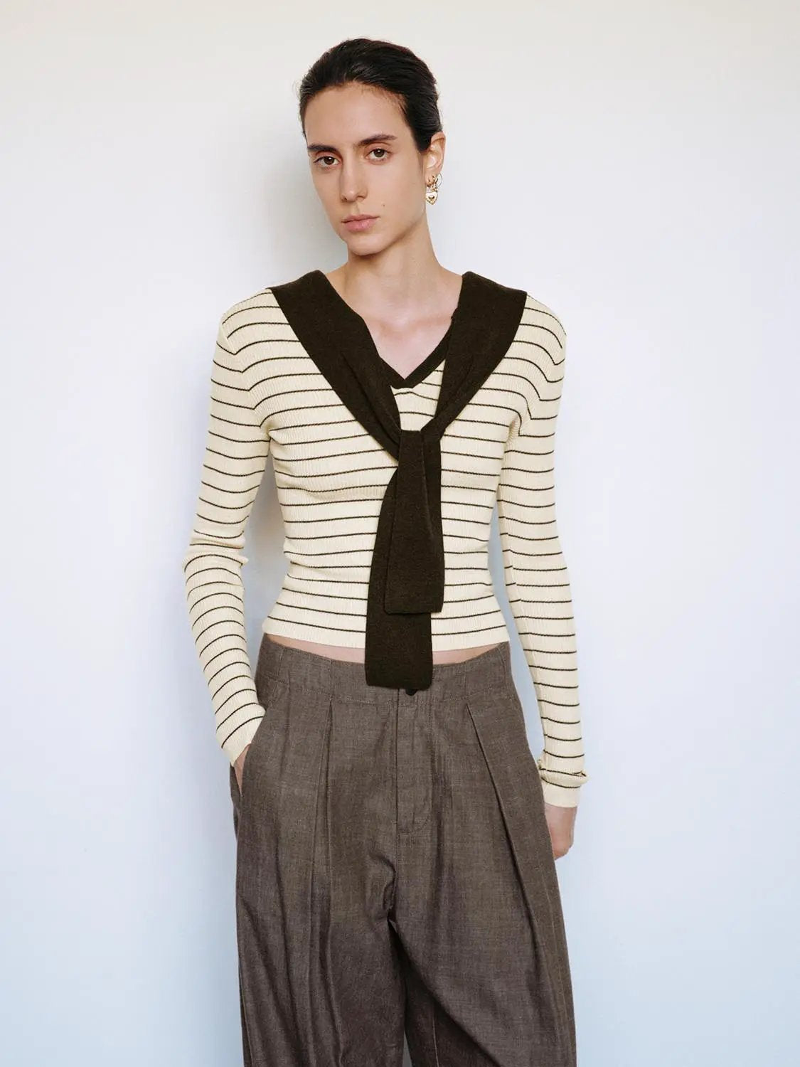Striped fitted knit T-shirt with V-neck and shawl collar tie; cream with black stripes, long sleeves.