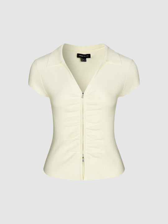 Cardigan aderente in maglia color crema, con arricciatura frontale e cerniera