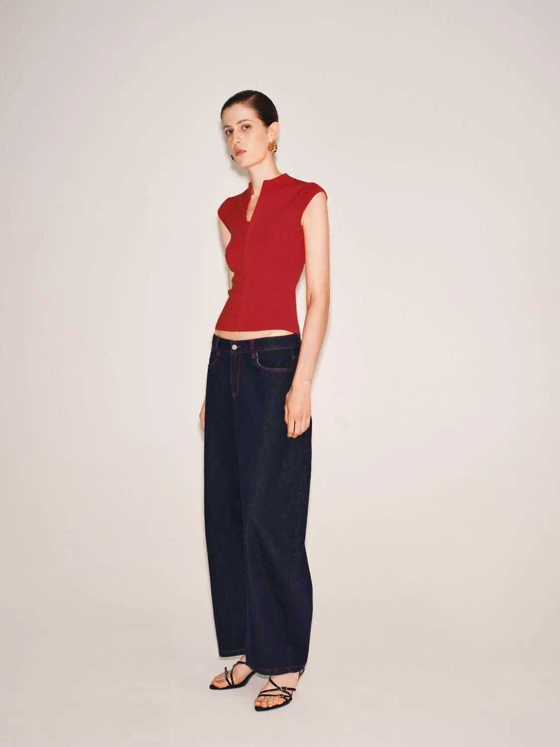 Knitted T-shirt, red sleeveless knit top with cropped fit, paired with dark wide-leg jeans