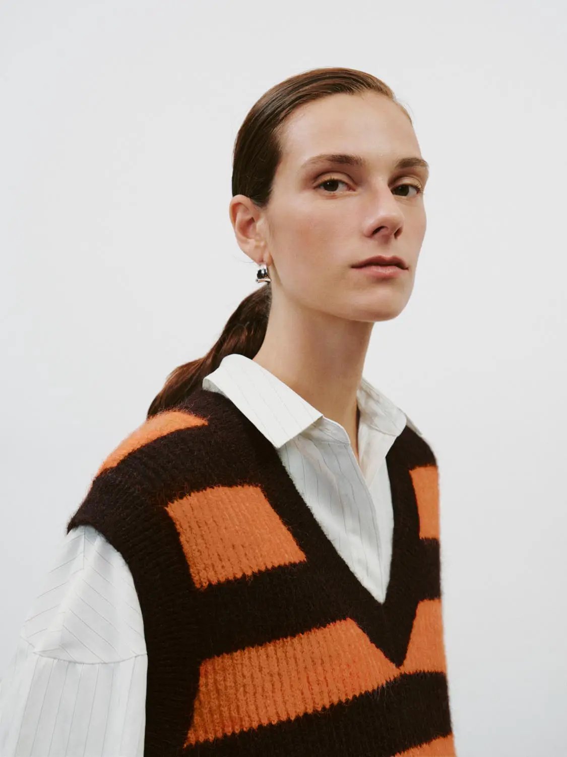 Striped stretch V-neck sleeveless knit tank top in orange and black.