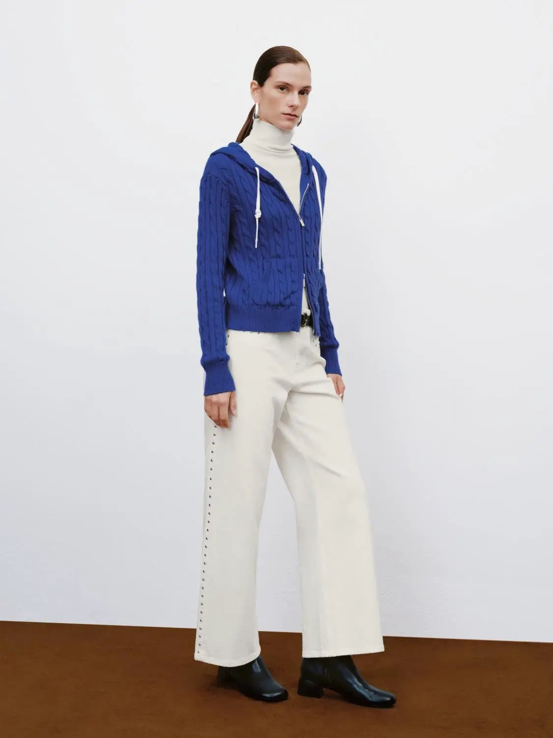 Cable-knit zip-front hoodie cardigan in royal blue with white drawstrings.