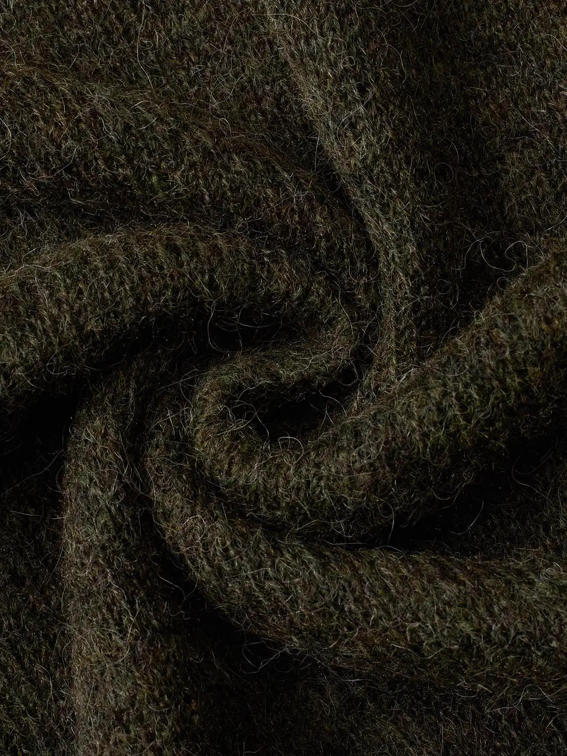 Knitted T-Shirt fabric close-up in dark olive green with fuzzy fibers