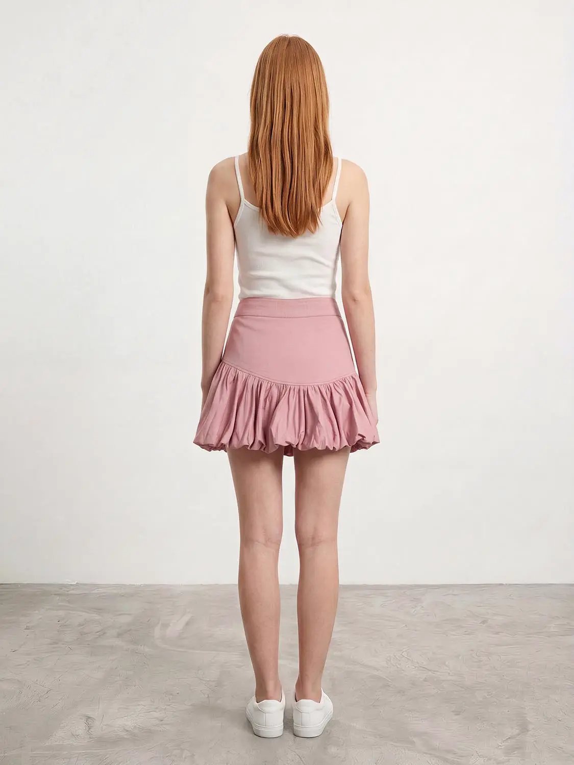 Pink tiered ruffle A-line skirt shown from the back.