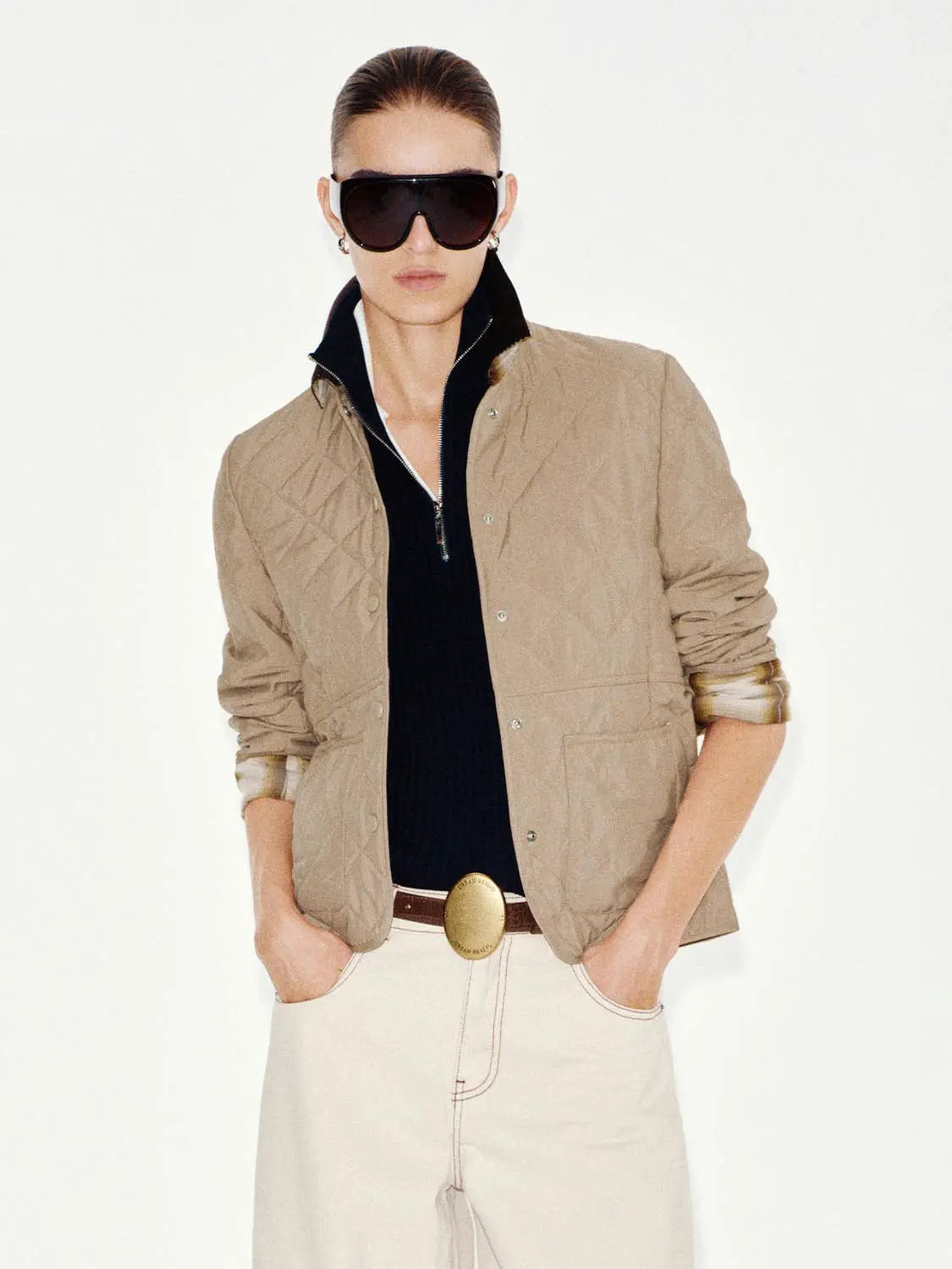 Padded jacket beige quilted with zip, worn by model in black top and oversized sunglasses