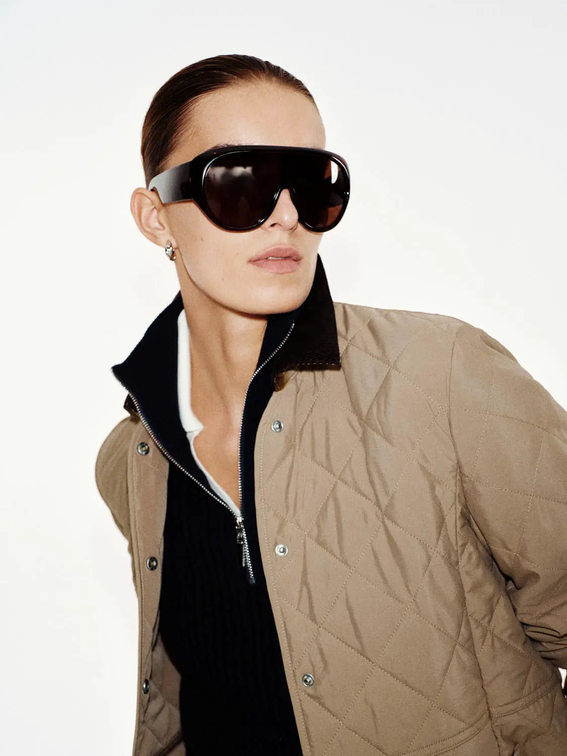 Padded Jacket, tan quilted with black collar, zip front, worn by a model.