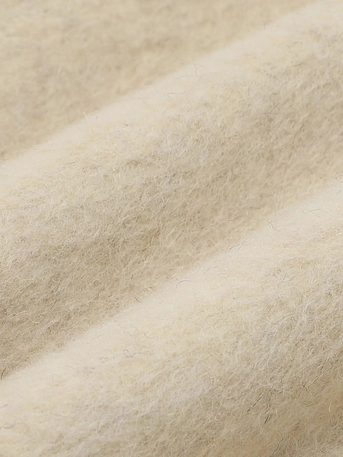 Coat fabric close-up in beige, soft fuzzy wool-blend texture