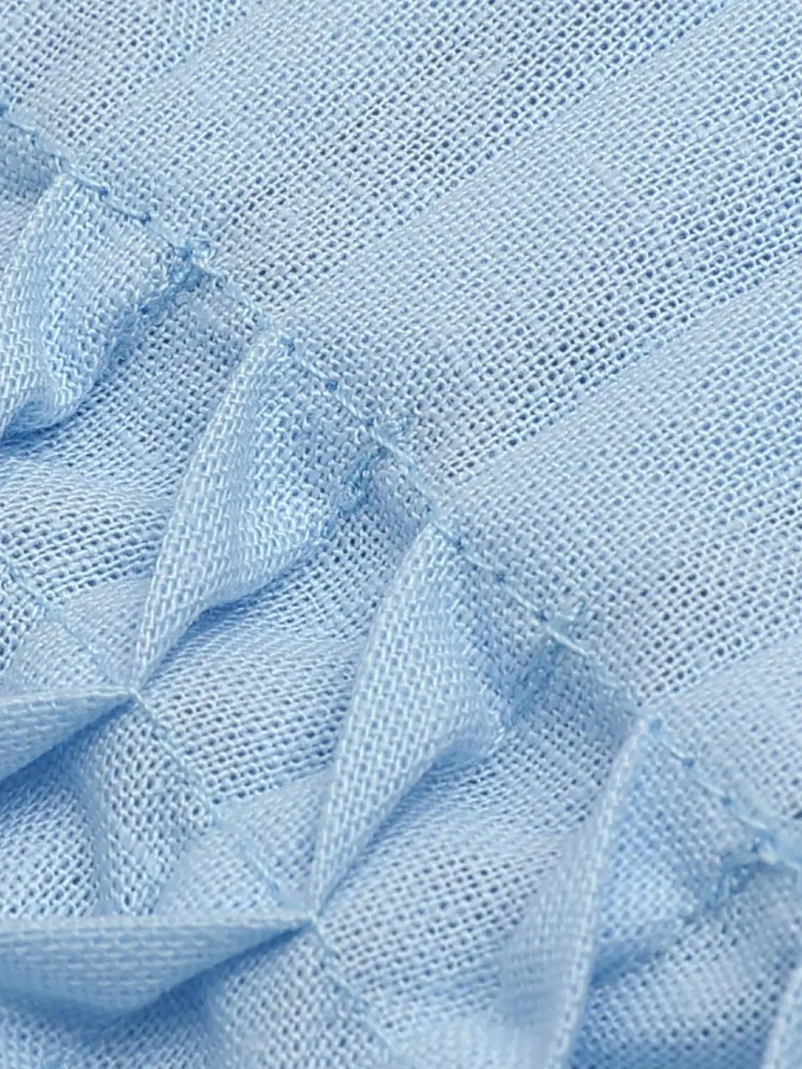 V-neck puff sleeve blouse in light blue cotton–linen blend, close-up fabric texture.