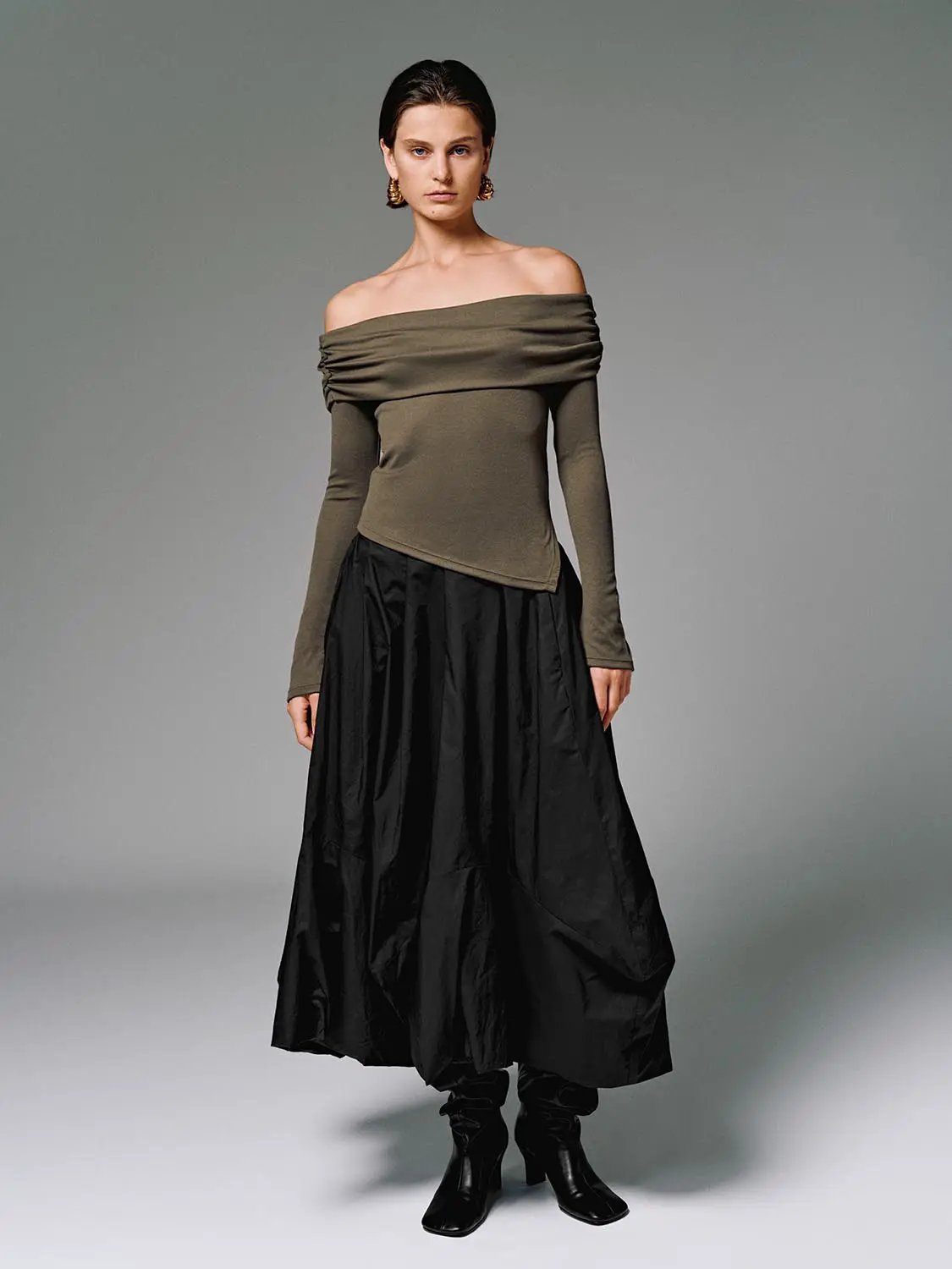 Off-shoulder olive long-sleeve top with black skirt; two-piece outfit.